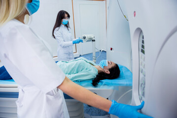 Radiologist with a female patient in the room of computed tomography