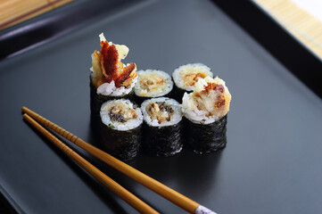 tasty and colorful sushi rolls served on a black plate