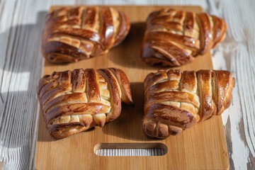 Appetizing fresh homemade buns on a wooden background, close-up.