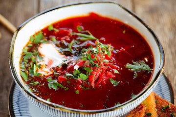 Russian nnational cuisine beetroot soup borsch on the wooden table