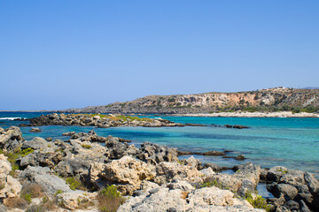 Fototapeta na wymiar The other side of Elafonisi beach, a stone beach overlooking the blue sea. Crete island, Greece