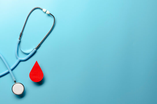 Blood drop symbol with stethoscope on blue background. Hemophilia day, blood donor day. Concept