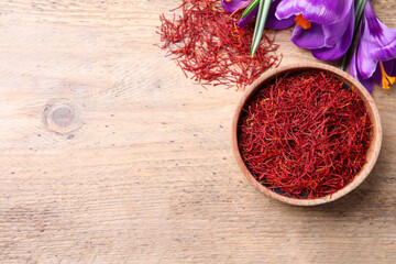 Obraz na płótnie Canvas Dried saffron and crocus flowers on wooden table, flat lay. Space for text