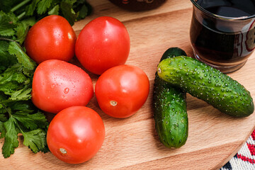 Tomatoes, cucumbers and herbs on a cutting board