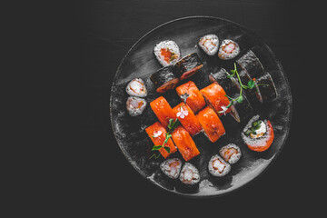 set of sushi roll with salmon, avocado, cream cheese, cucumber, rice, tuna in plate on black background