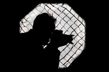 Silhouette of a photographer against a large light softbox with honeycomb grid, typical of a photo...
