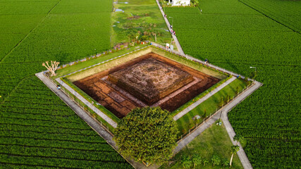 Aerial drone view of Blandongan temple at Karawang and surrounded by green grass with noise cloud. Karawang, Indonesia. March 21, 2021