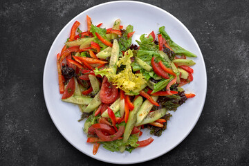 Spring salad of fresh vegetables on a dark background