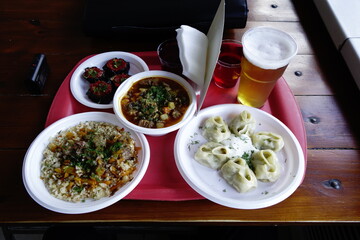 Lunch at a Russian fast food cafe of Uzbek Lagman soup, pilaf, manti served on disposable plates