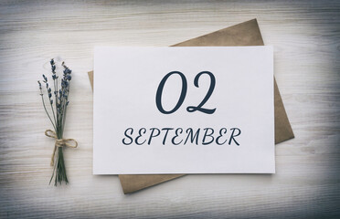 september 02. 02th day of the month, calendar date.White blank of paper with a brown envelope, dry bouquet of lavender flowers on a wooden background. Autumn month, day of the year concept