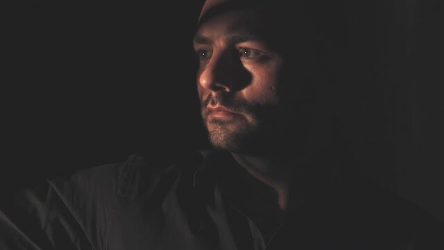 Portrait of a man in a black shirt. Light and shadow
