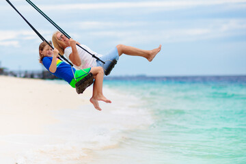 Child on beach swing. Summer vacation.