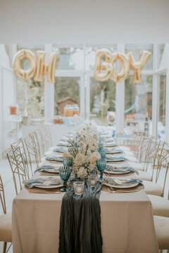 baby blue and gold table setting at a baby party, baby shower, gender reveal party