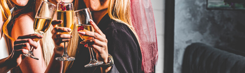 Women's hands with glasses of champagne wine. Clinking glasses of champagne in hands
