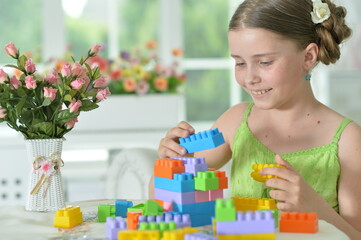  girl playing with colorful plastic blocks