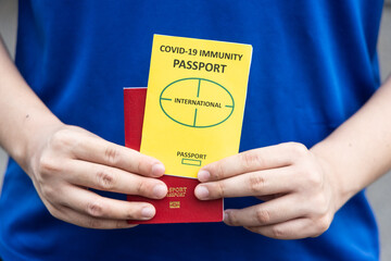 Closeup of person holding the conceptual Covid-19 Immunity Passport document ready to travel