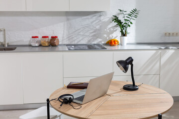 laptop on wood table in modern kitchen room.
