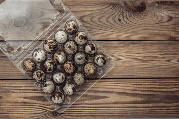 Tray with quail eggs on a wooden table. Top view