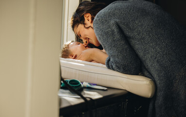 Obraz premium Woman playing with baby lying on changing table