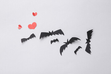 Paper cut bats and hearts on a gray background. Halloween, love background