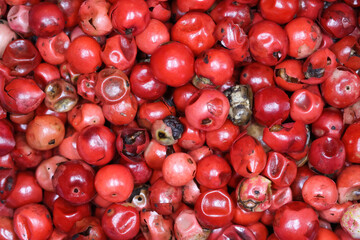 Full frame macro wallpaper closeup of many colorful red raw peppercorns