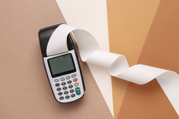 Payment terminal with paper tape on colored background - obrazy, fototapety, plakaty