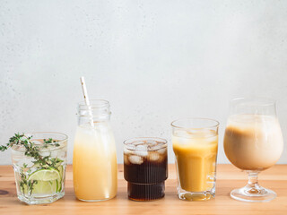 Various refreshing non-alcoholic drinks in glasses with ice.
