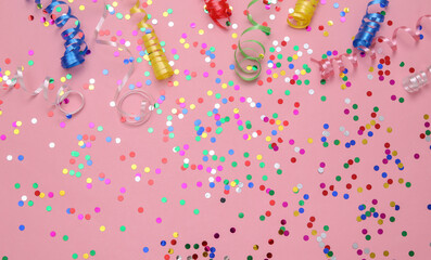 Colored streamer and confetti on a pink background. Holiday, birthday background