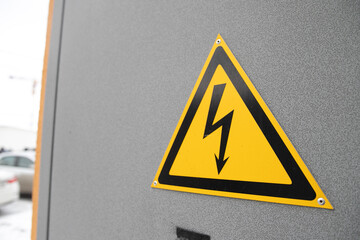 Sign of high voltage on a gray metal surface.