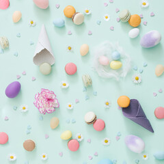 Fototapeta na wymiar Easter creative chaos with eggs, ice ceam cone macarons and flowers on the pastel green background. Flat lay composition.