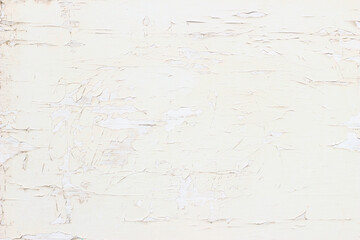 Closeup of old painted wooden door with cracked texture. Grunge rustic backdrop. Dirty cream white and pale yellow background. Vintage wall structure. Empty copy space.