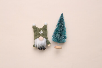 Christmas gnome and Christmas tree on beige background. Top view