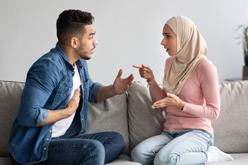 Emotional muslim man and woman fighting at home