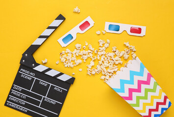 Flat lay composition of clapper board, popcorn, 3D glasses on yellow background. Top view