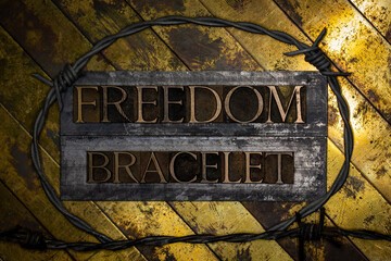 Freedom Bracelet from barbed wire with text on vintage textured grunge copper and gold background