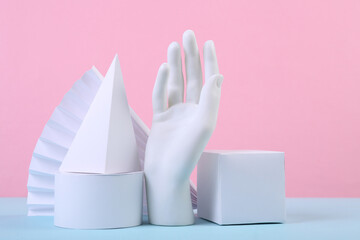 Geometric figures and hand on a blue-pink pastel background. Composition of different geometric objects. Concept art. Abstract background, minimalism