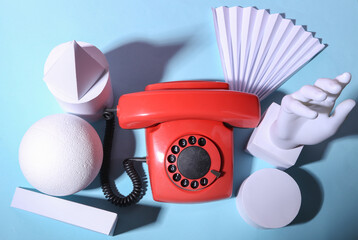 Retro rotary phone and geometric shapes on blue pastel background. 80s concept art