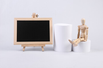 Empty chalk board with wooden puppet and geometric shapes on white background. School composition....