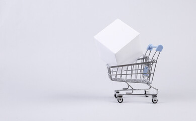 Shopping cart with white cube on white background