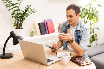 Handsome young man online using a laptop