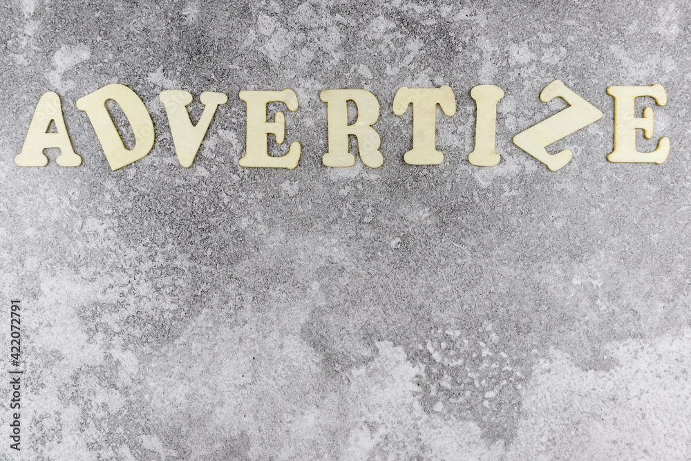 Fototapete advertize concept with offset alphabet letters forming a top border on a textured grey background wi