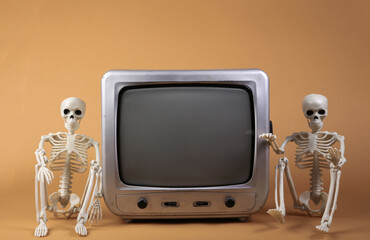 TV and skeletons on a beige background.