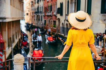 woman in yellow sundress at bridge with view at venice canal