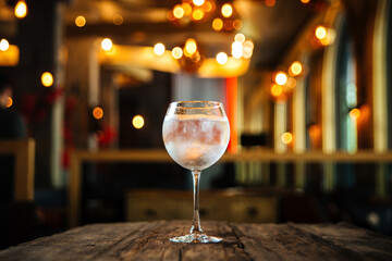 Glass of gin tonic cocktail with on the wooden desk with a blurry background
