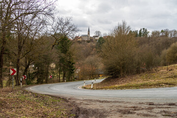 90° curve in a mountainous area with a church in the background 