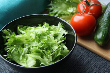 Frieze, tomatoes and cucumber prepared for slicing salad on a wooden background.