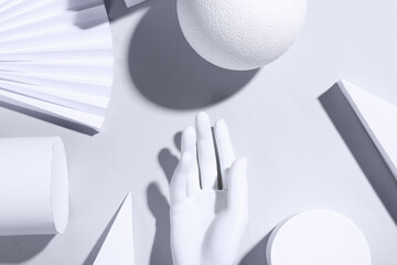 Minimalism white background with  geometric shapes and mannequin hands. Trendy shadows