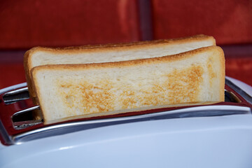 A close-up of two toasted toast breads. Two toasts on a background of a red brick wall. Fried toast...