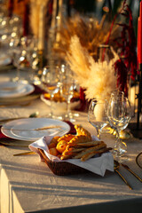 Decorated outdoors nature banquet table set with candles and dried flowers