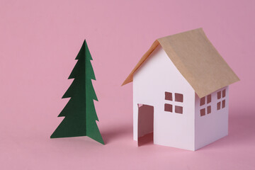 Paper House model and a Christmas tree on pink background.